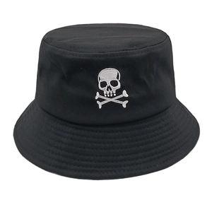 Détail de la broderie tête de mort blanche sur un chapeau bob en coton noir