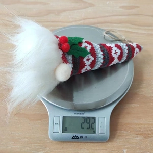 Close-up of a Christmas gnome pendant on a kitchen scale showing 29.2g weight