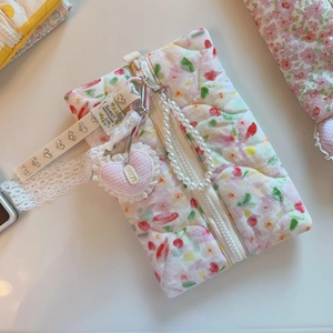 Gros plan sur une pochette matelassée fleurie rose avec perle et dentelle