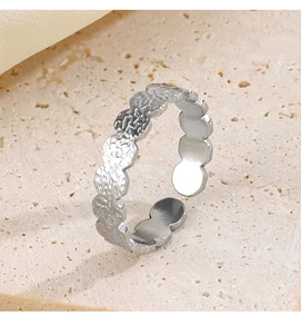 Detail shot of vintage silver hammered square texture ring on stone and silk background