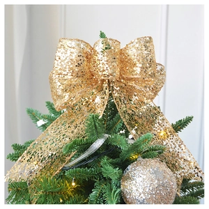Detail of champagne gold sequin mesh bow topper decorating a Christmas tree top