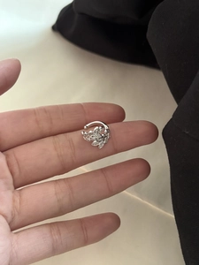 Detailed view of silver zircon leaf ear cuff shown on hand for size perspective
