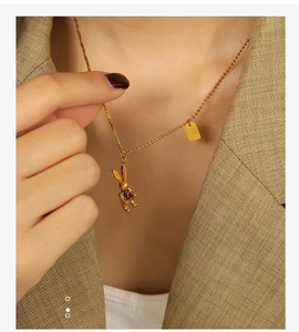 Close-up of golden mechanical rabbit pendant necklace on a khaki suit model jacket