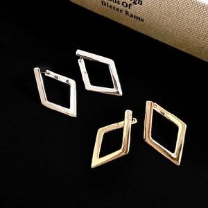 Detailed macro view of geometric diamond earrings in gold and silver metal finish