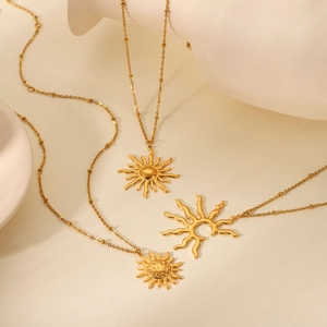 Close-up of three gold stainless steel sun pendant necklaces with refined bead chains