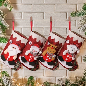Close-up of four linen Christmas stockings with 3D Santa, Snowman, Reindeer, and Bear motifs