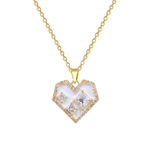 Gold heart necklace with white enamel inlay and sparkling zircon crystals on white background
