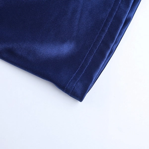 Macro view of double-needle stitching and dark blue fabric texture on the elegant evening gown