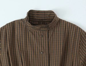 Detail of stand-up collar and brown plaid fabric texture on women's cotton shirt