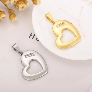 Detail of gold and silver hollow heart pendants with three inlaid clear zircons