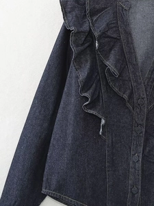 Detailed close-up of ruffle layers and denim texture on this dark blue button-up shirt