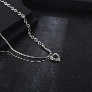 Double-layered silver necklace with snake chain, link chain, and black heart pendant
