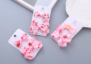 Detail of pink handmade ribbon bow hair clips with cherry, strawberry and mushroom patterns
