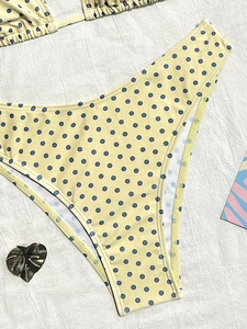 Dettaglio del pezzo sotto del bikini giallo a pois blu con taglio a gamba alta