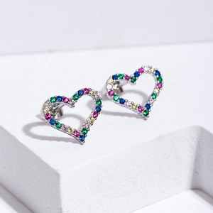 Fashionable heart-shaped stud earrings with colorful zircon stones on a white stand
