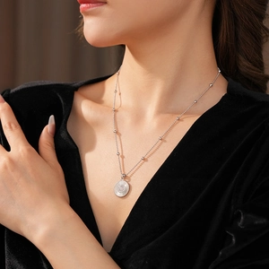 Collier à pendentif marguerite en argent avec chaîne à billes porté par un mannequin