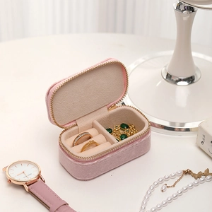 Pink velvet travel jewelry case with metal zipper, ring slots and interior organizers