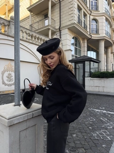 Outdoor street style shoot of a black crewneck sweatshirt with retro letter print detail