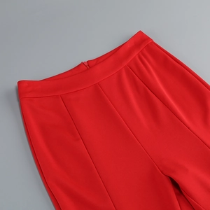 Détail du pantalon rouge à taille haute avec fermeture éclair invisible et coutures nettes