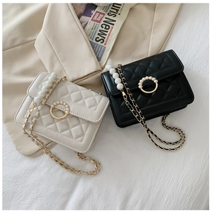 Detail of quilted chain bags with pearl handles and decorative circular clasps