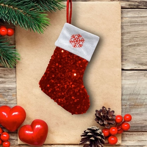 Detailed view of red sequin Christmas stocking with white cuff on a rustic wooden background