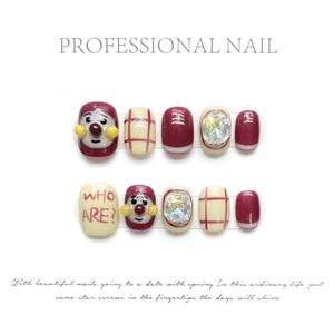 Detail of red and white handmade press-on nails with cartoon patterns and rhinestones