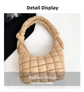 Detail shot of beige quilted puffer bag featuring knot handle design and gold zipper