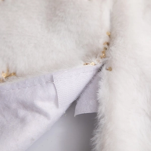 White plush Christmas tree skirt with golden sequins and soft faux fur texture