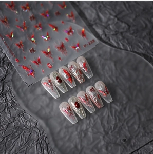 Macro detail of M-228 butterfly nail art stickers with 3D embossed texture and red gems