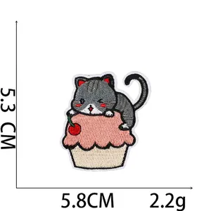 Close-up of a cartoon cat and cupcake embroidered patch with precise 5.3 x 5.8 cm dimensions