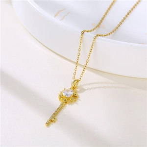18K gold plated stainless steel key necklace with zircon stones on white marble background
