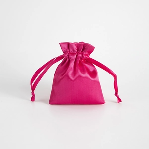 Detail of rose red satin drawstring bag with glossy texture for jewelry storage