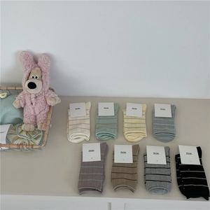 Close-up of eight pairs of Morandi-colored striped mid-calf socks with rolling edge detail
