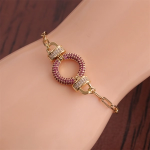 Close-up of gold hip hop bracelet with red and white zircons on model's wrist