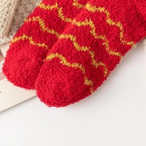 Gros plan sur des chaussettes de Noël rouges en polaire avec motifs à vagues jaunes