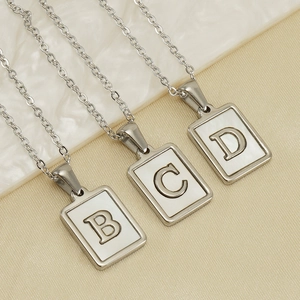 Silver square shell letter necklaces featuring B, C, and D pendants on marble surface