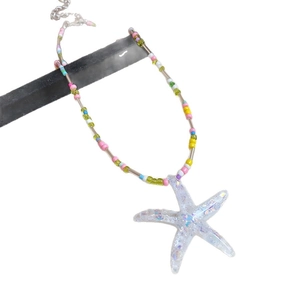 Beaded necklace with colorful beads and a glitter-filled starfish pendant on white