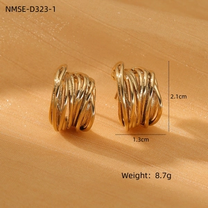Detail of gold twisted earrings with dimensions 2.1cm by 1.3cm on orange silk