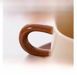 Detail einer nordischen Keramik-Kaffeetasse mit dickem braunem Griff und glänzender Glasur