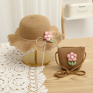 Close-up of girls' straw sun hat and matching crossbody bag with pink floral accents