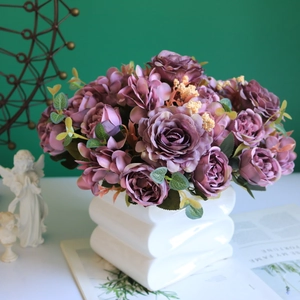 Close-up of vintage purple silk roses and hydrangeas in a white ceramic vase