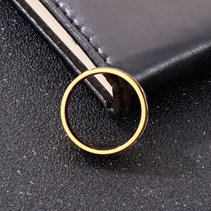Detail shot of a minimalist 18k gold plated titanium ring on a black leather notebook