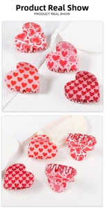Detail shot of heart-shaped hair claw clips with various pink patterns and inner structure