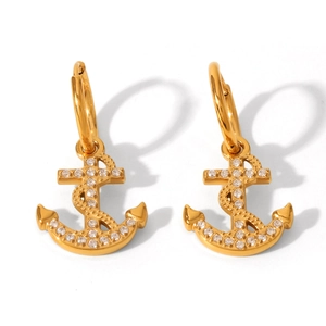 Macro detail of 18K gold-plated anchor earrings with shimmering micro-pave crystals