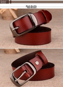 Close-up of reddish brown leather belt with black pin buckle and metallic rivet detail