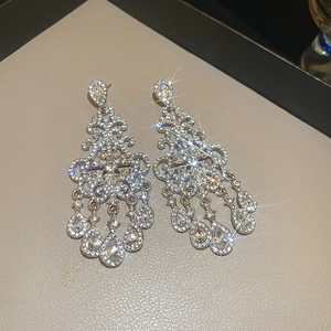 Close-up of sparkling silver drop tassel earrings with floral cubic zirconia stones
