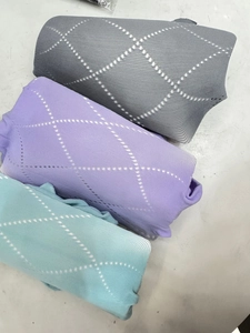 Détail de la texture en tricot à losanges ajourés en gris, violet et vert menthe