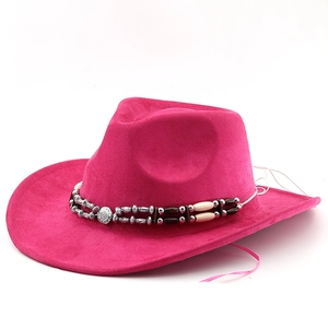 Detail of rose red suede cowboy hat featuring ethnic beads and engraved metal disc