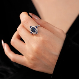 Vue détaillée d'une bague halo vintage avec saphir bleu foncé et zircons cubiques brillants