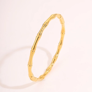 Vista dettagliata di un bracciale in acciaio inossidabile dorato con design a bambù